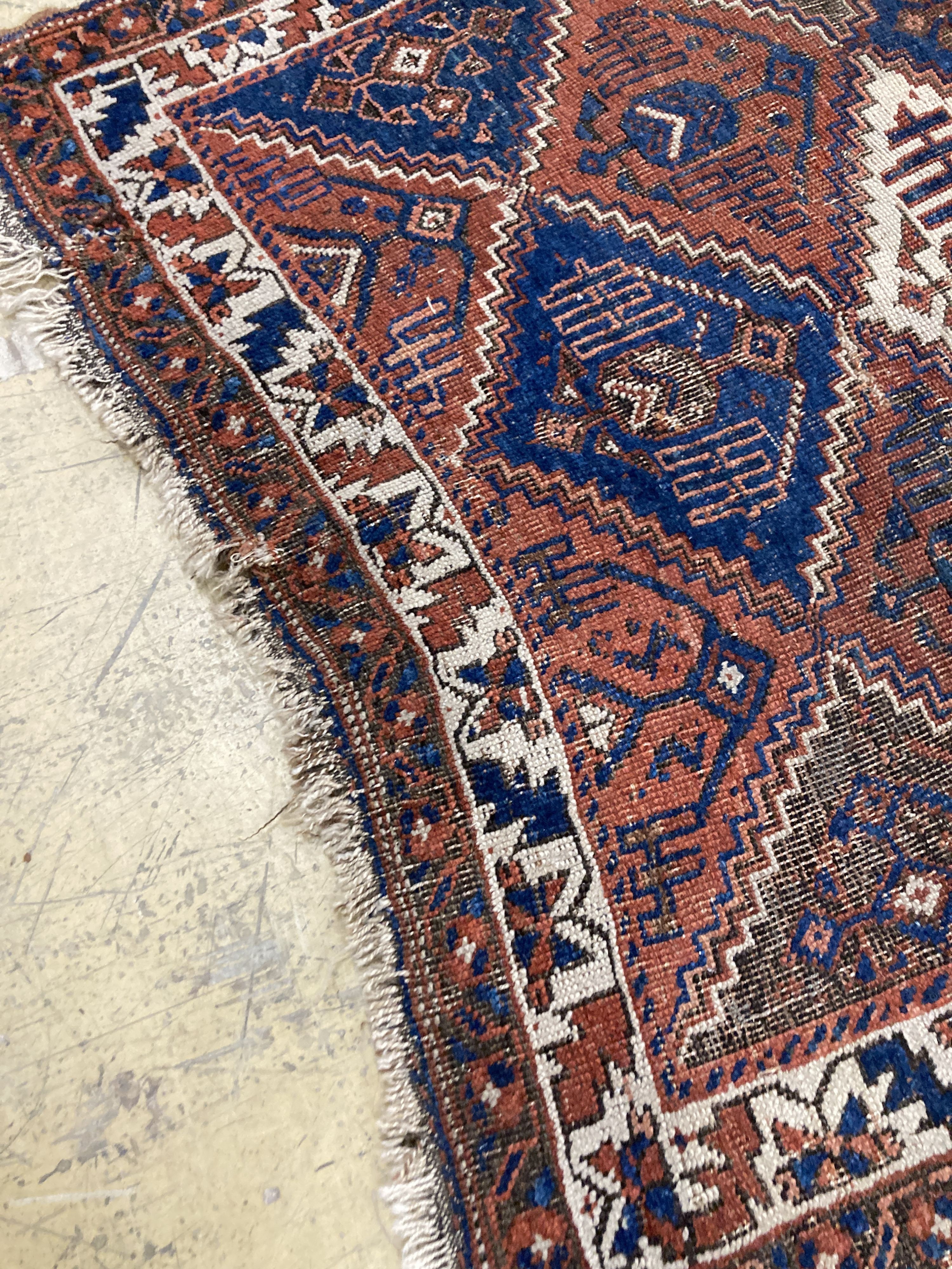 An antique Caucasian red ground rug, 250 x 125 cm and a smaller Shiraz rug.